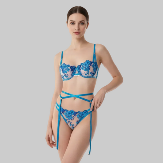 Woman wearing a blue lace lingerie set on a gray background