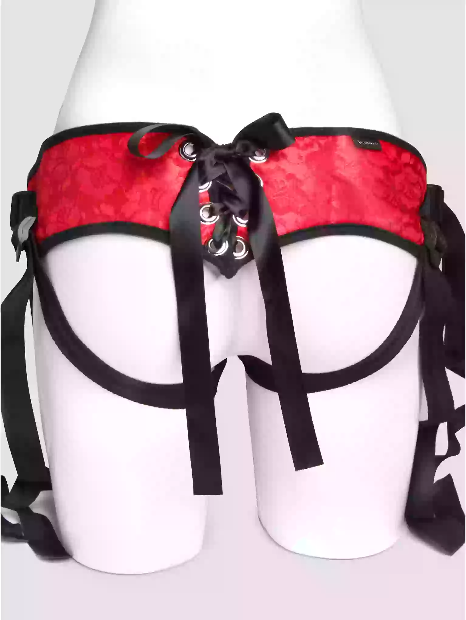 Red satin harness with black straps on a white mannequin.