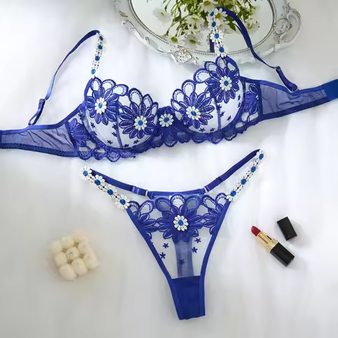 Blue lace lingerie set on a white surface with decorative elements.