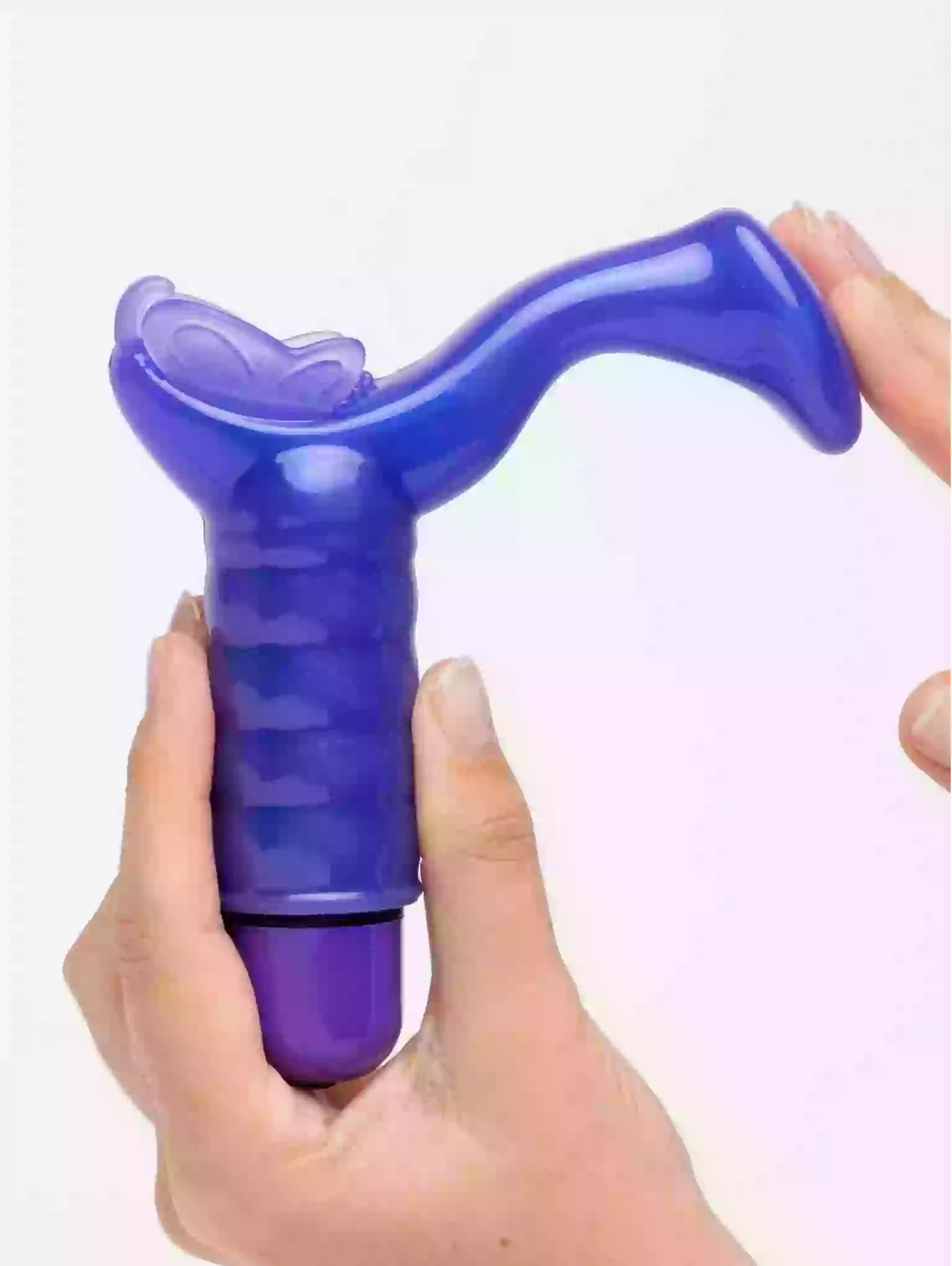 Purple and black device held in a hand against a white background