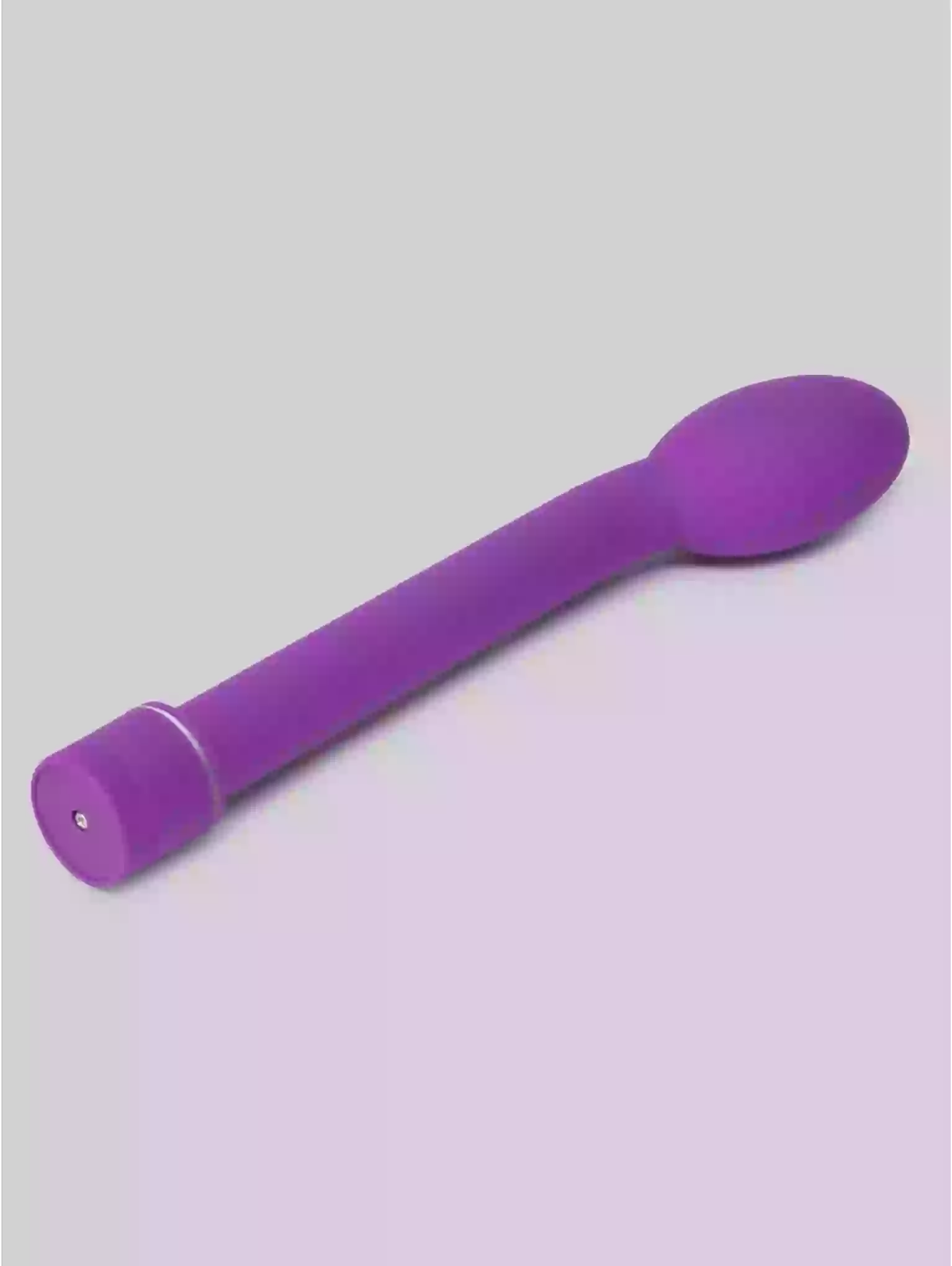 Purple plastic spoon on a gray background