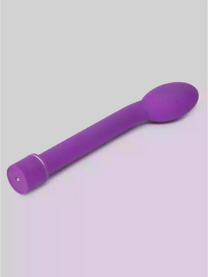 Purple plastic spoon on a gray background