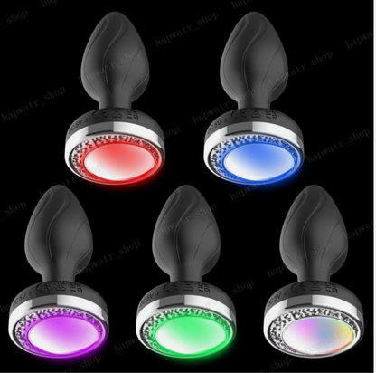 Set of five LED butt plugs in different colors on a black background.