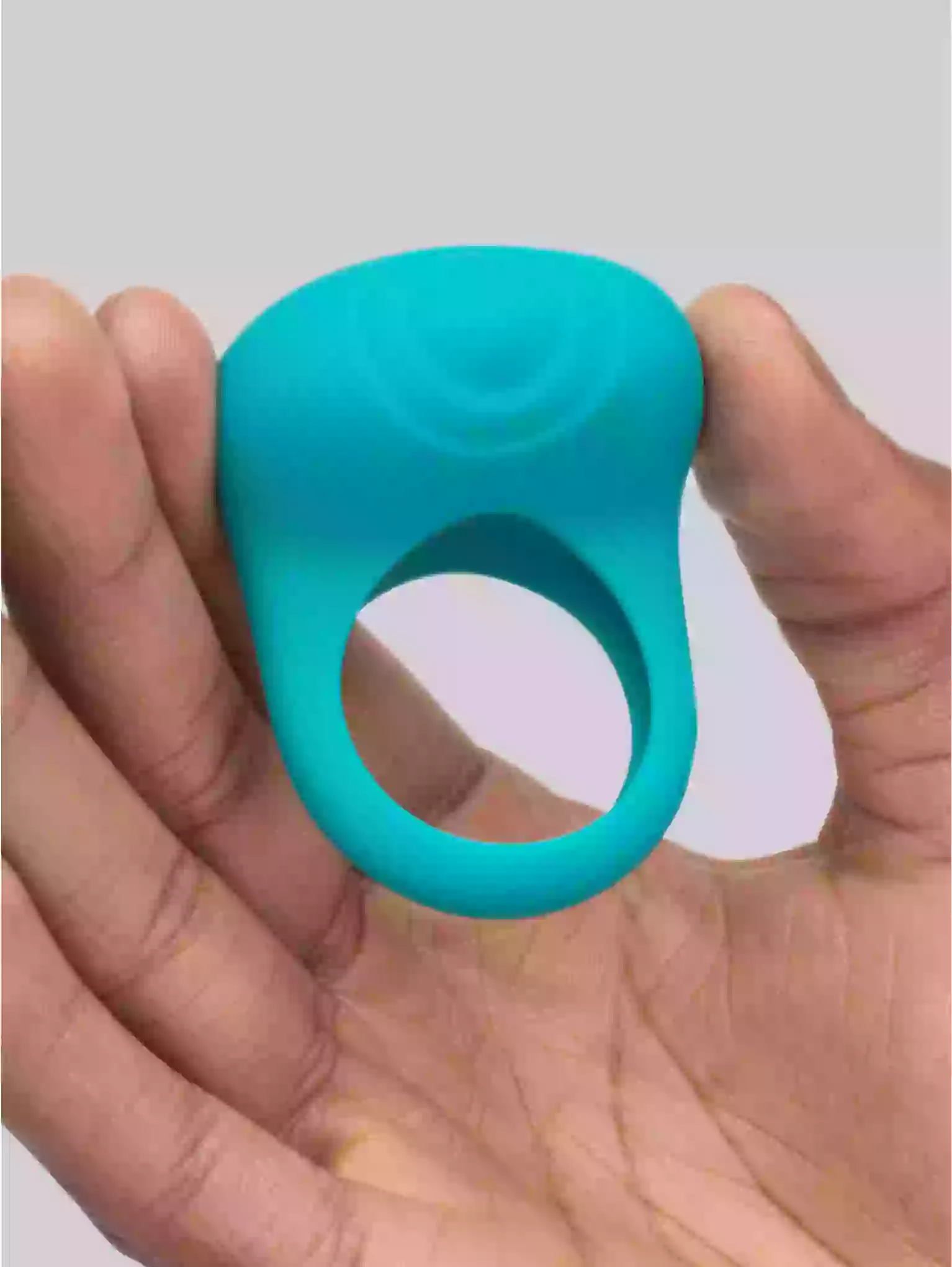 Turquoise silicone ring held in a hand against a neutral background