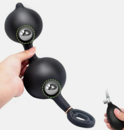 Black handheld device with a metallic ball, held by a hand on a white background