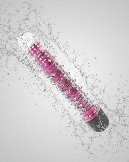 Pink and clear object with water droplets on a gray background