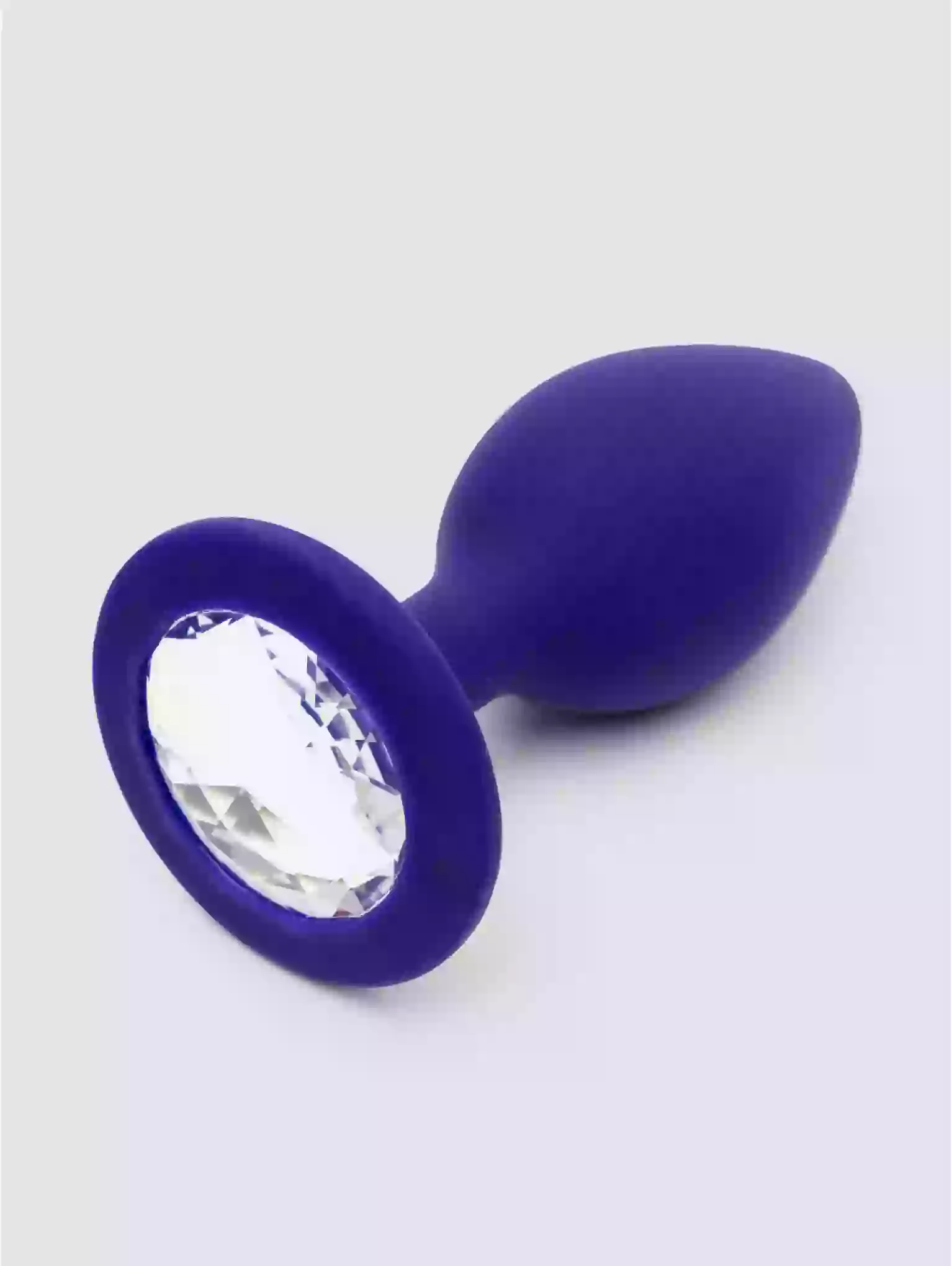 Purple silicone butt plug with a crystal-like center on a white background