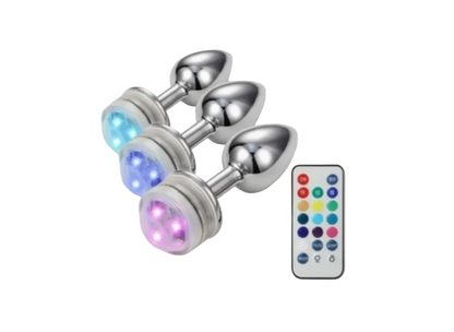 Metallic butt plug with LED lights and remote control on a white background