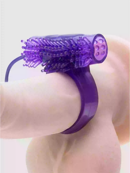 Purple handheld massager with bristle head on a light background