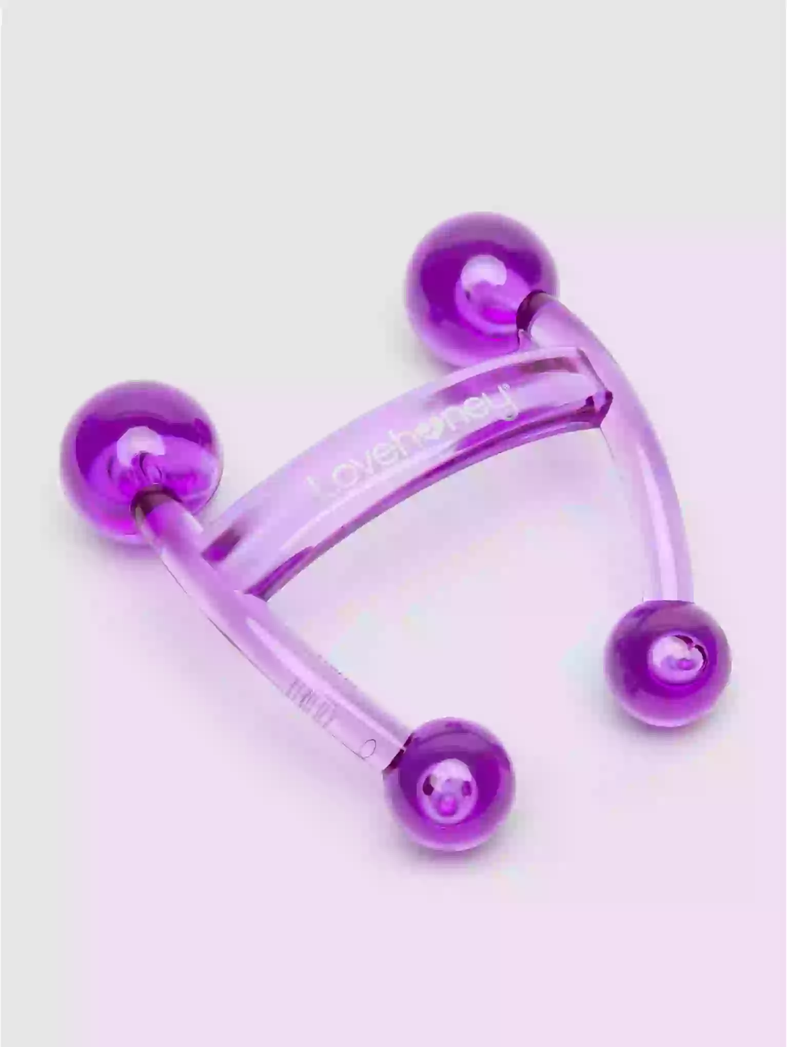 Purple plastic tool with spherical ends on a light purple background