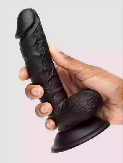 Black silicone suction cup with textured design held by a hand against a light gray background