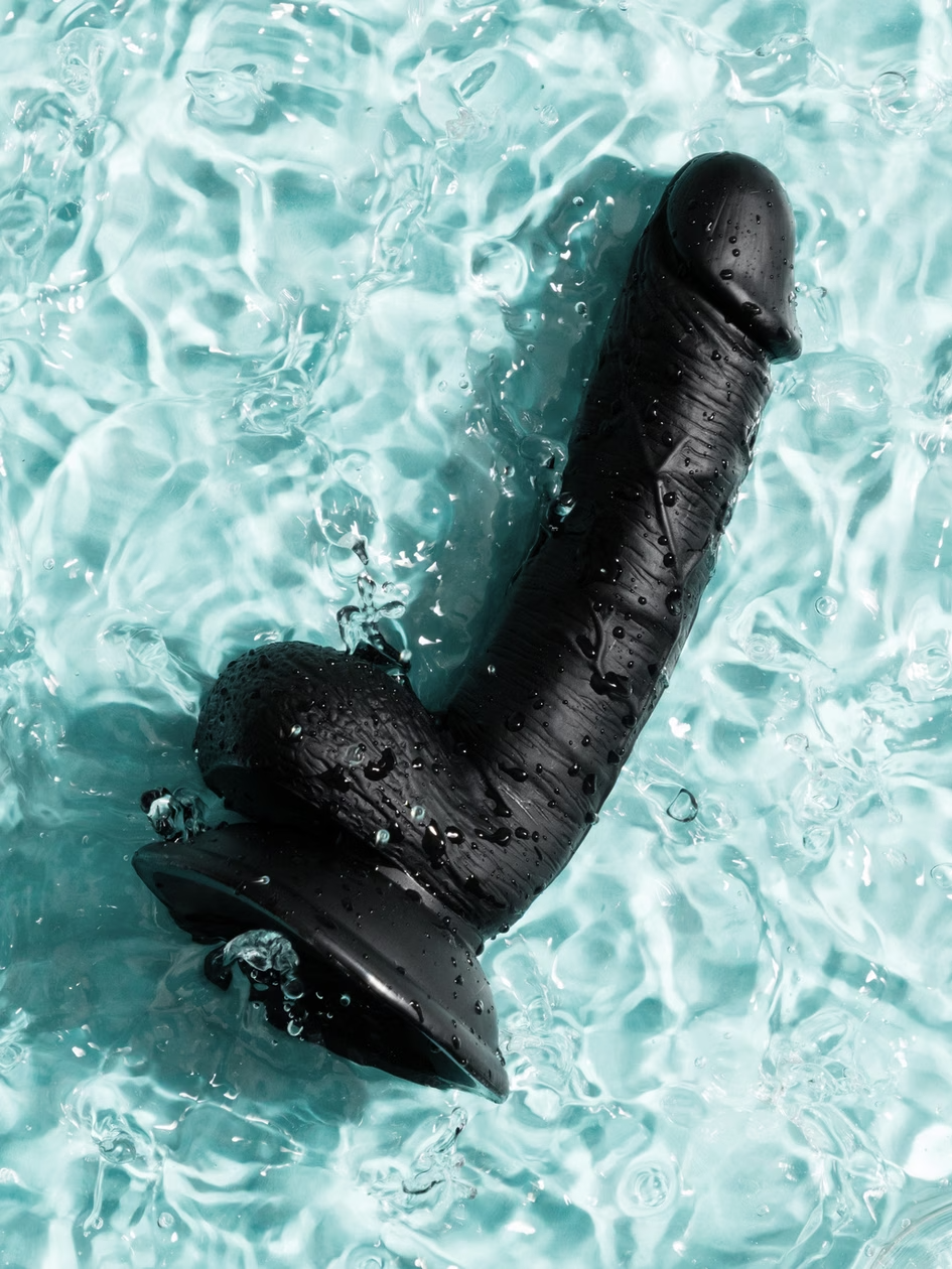 Black shark-shaped object in clear blue water