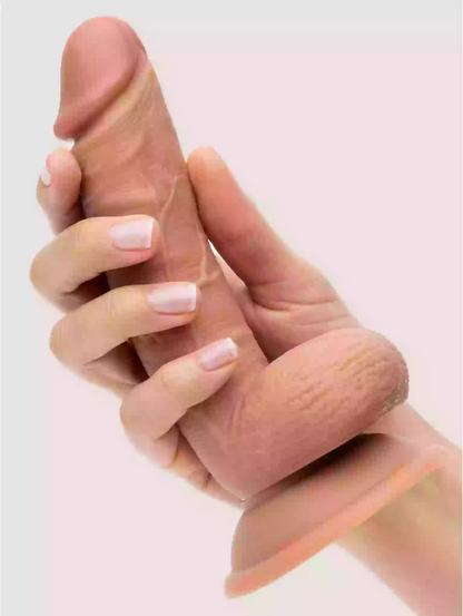 Hand holding a silicone product against a light pink background