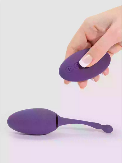 Purple silicone product held by a hand on a light gray background