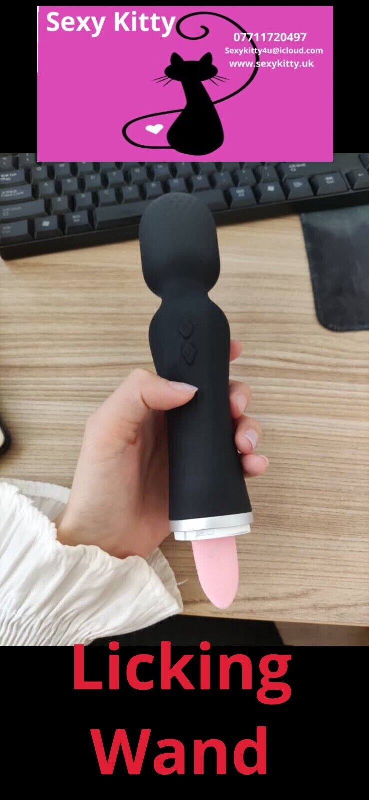 Hand holding a 'Licking Wand' with promotional text and contact information on a desk.