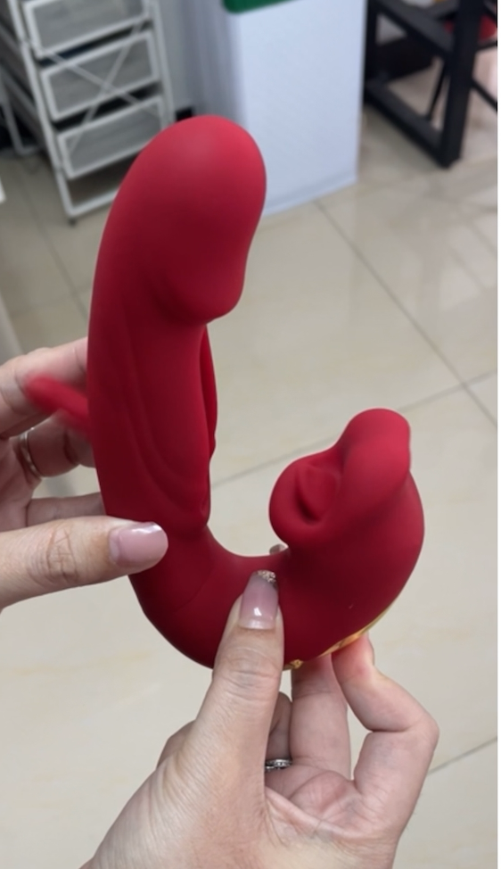 Red silicone product held by a hand with a blurred background