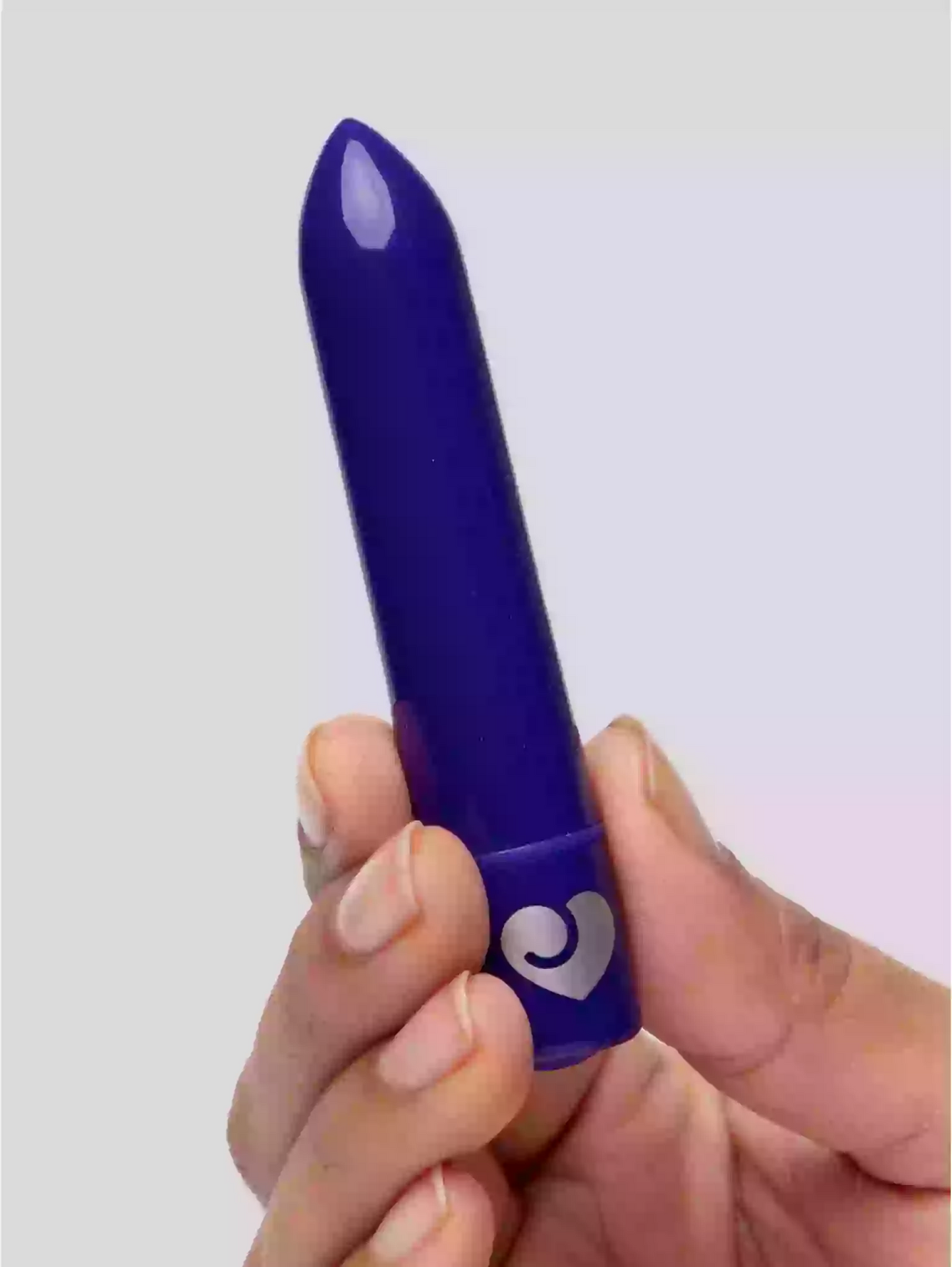 Blue lipstick held by a hand against a light background