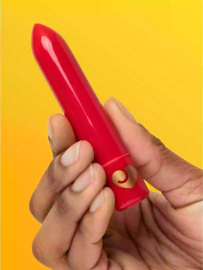 Hand holding a red lipstick against a yellow background