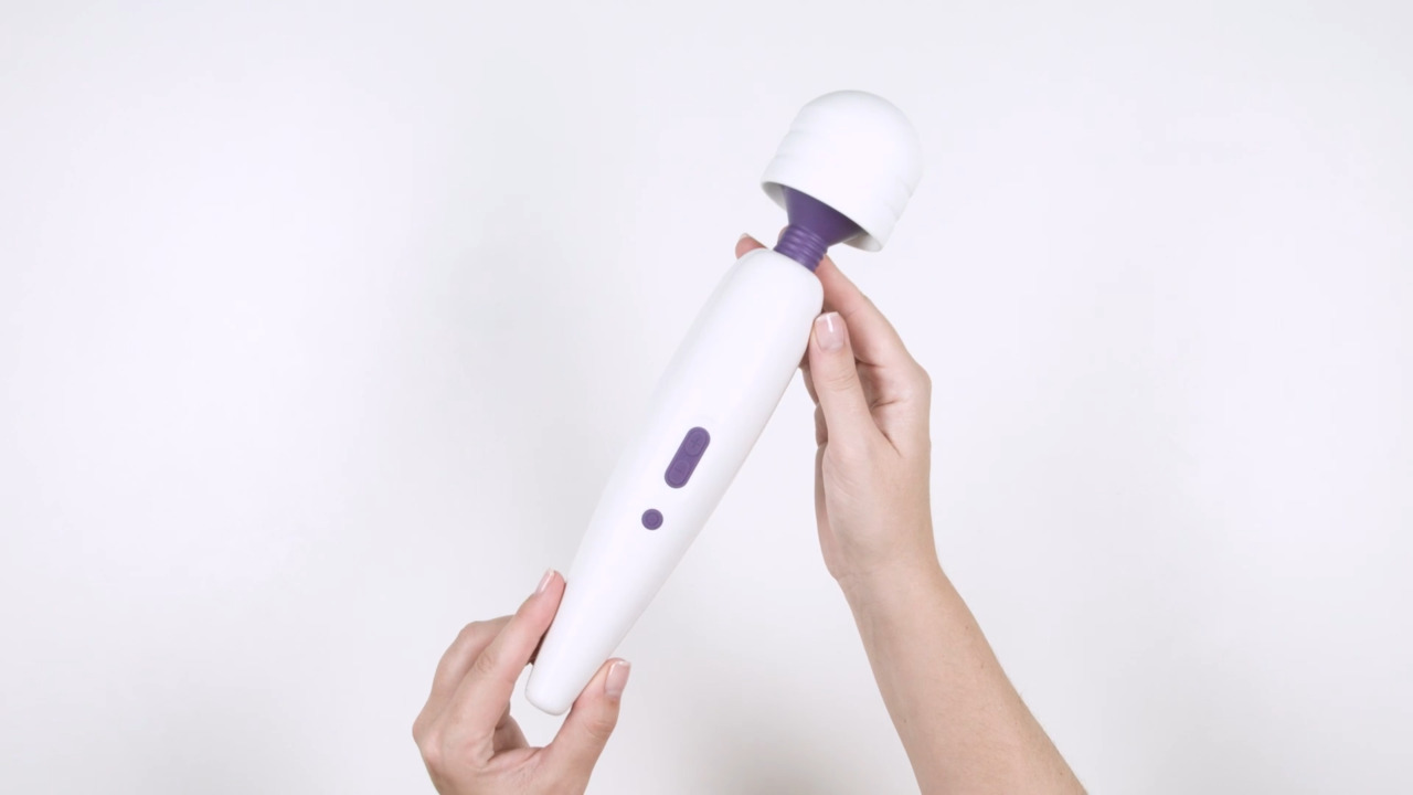 White and purple handheld device held by a hand on a white background