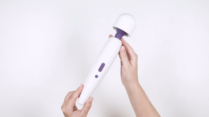 White and purple handheld device held by a hand on a white background