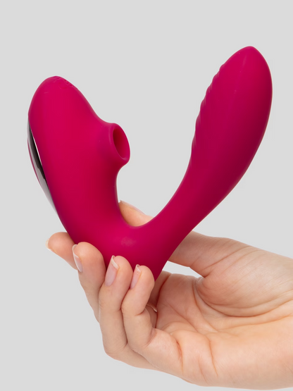 Pink and silver device held in a hand against a gray background