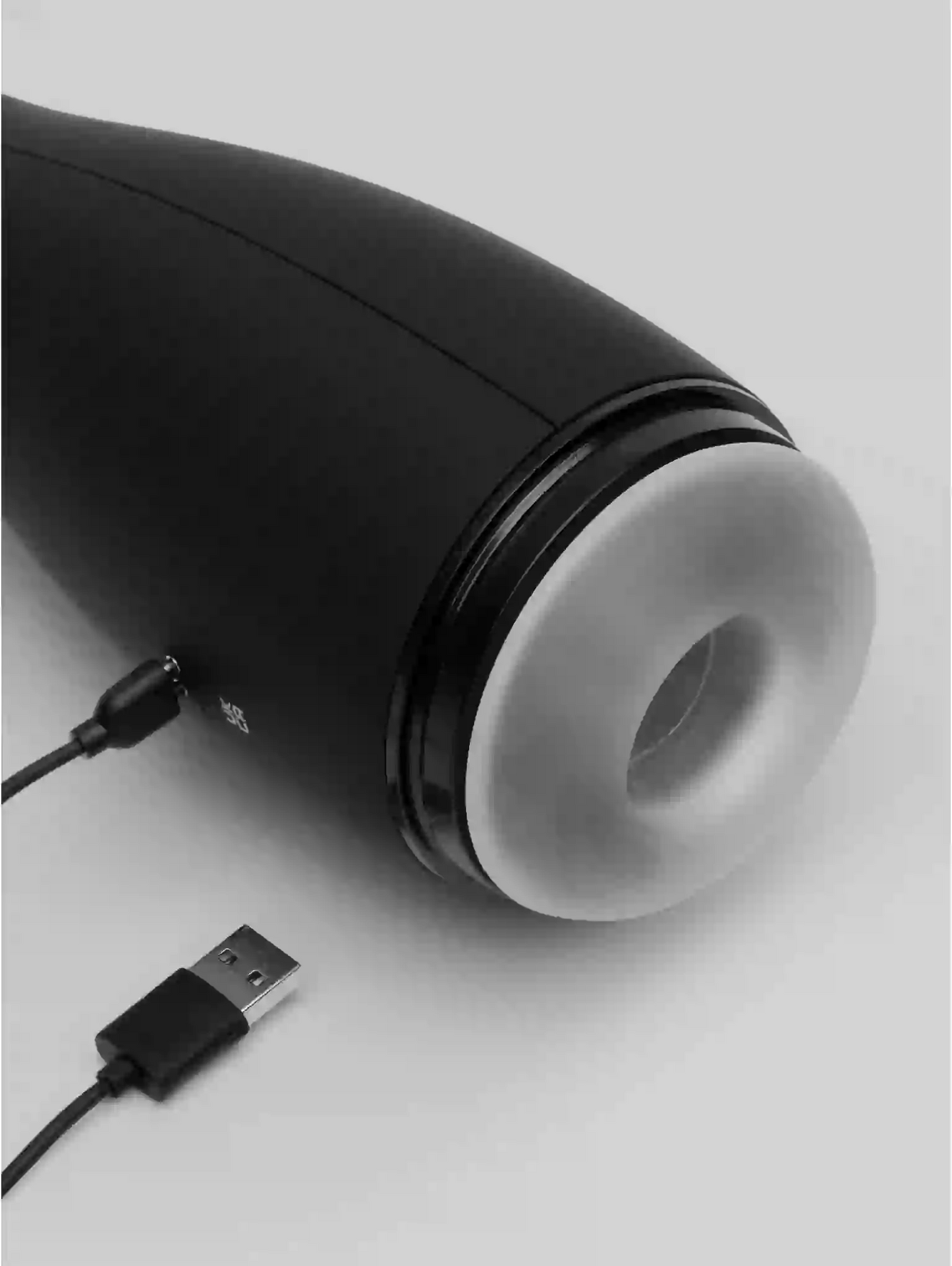 Black and white cylindrical device with a USB cable on a light gray background
