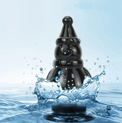 Black object emerging from water with a light blue gradient background