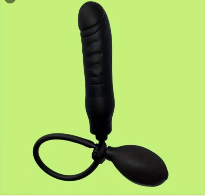 Black rubber dildo on a green background