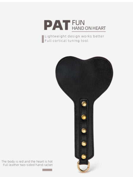 Black heart-shaped tool with gold accents on a white background