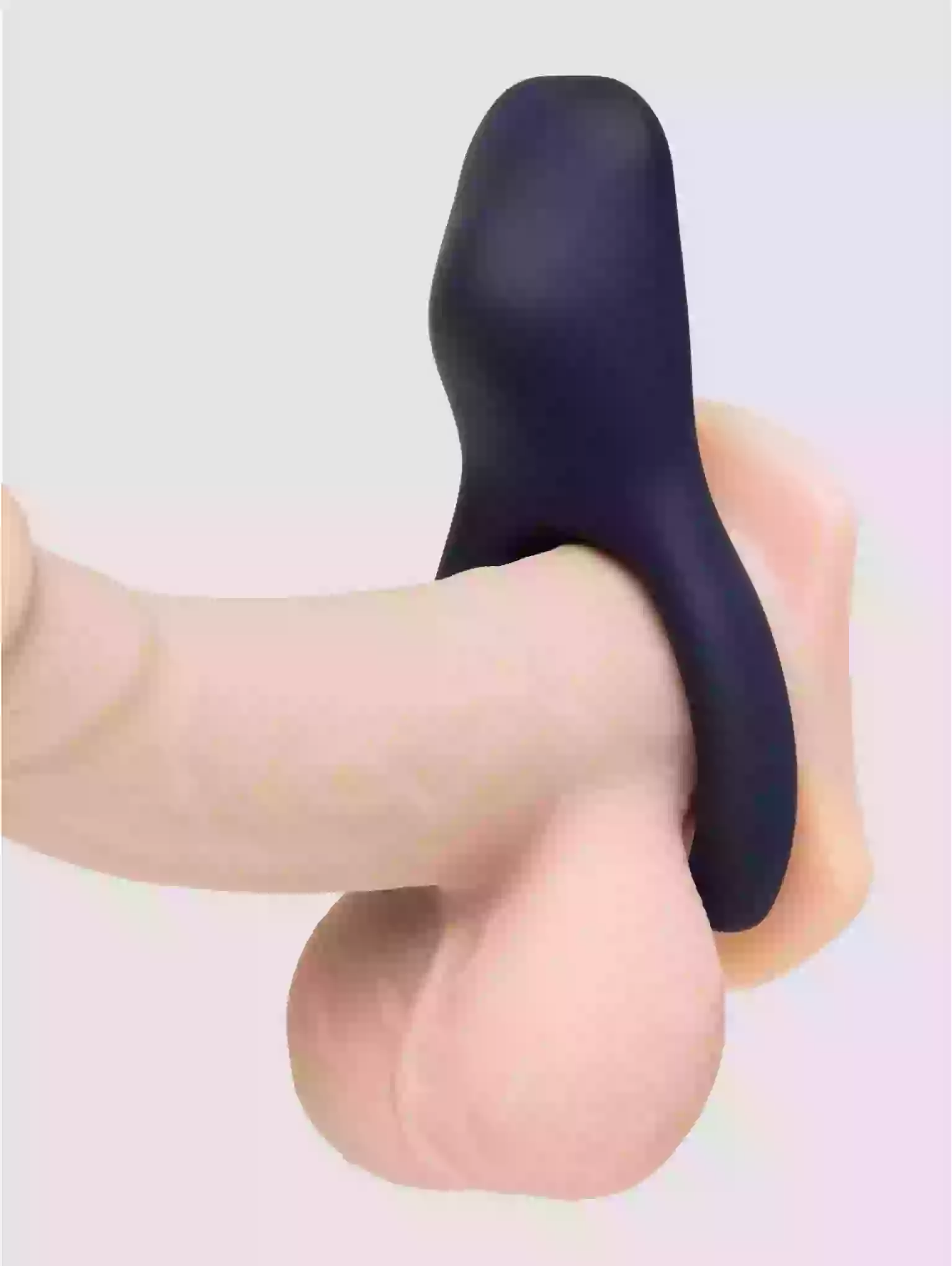 Black silicone product being held by a hand on a light gray background