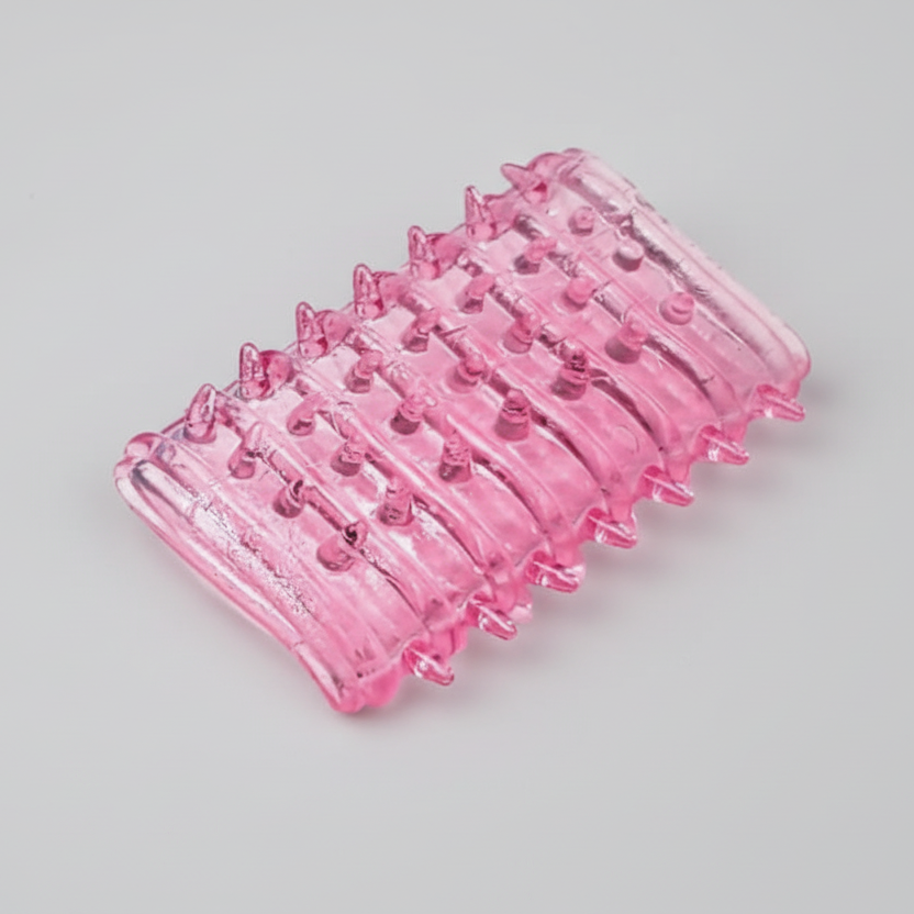 Pink plastic tool with multiple prongs on a gray background