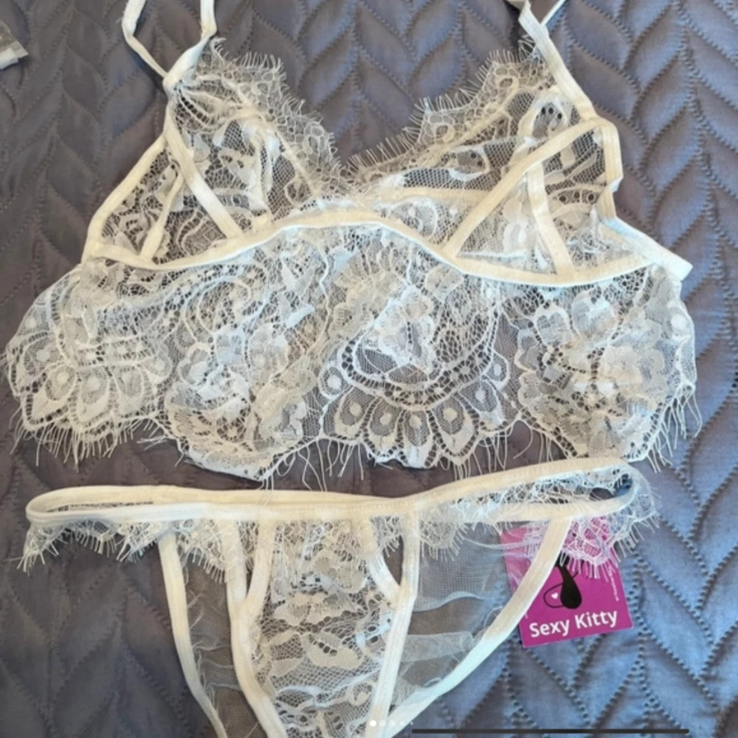 Lace lingerie set with 'Sexy Kitty' tag on a textured surface