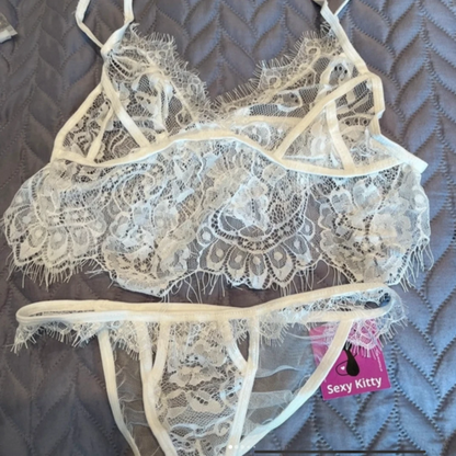 Lace lingerie set with 'Sexy Kitty' tag on a textured surface