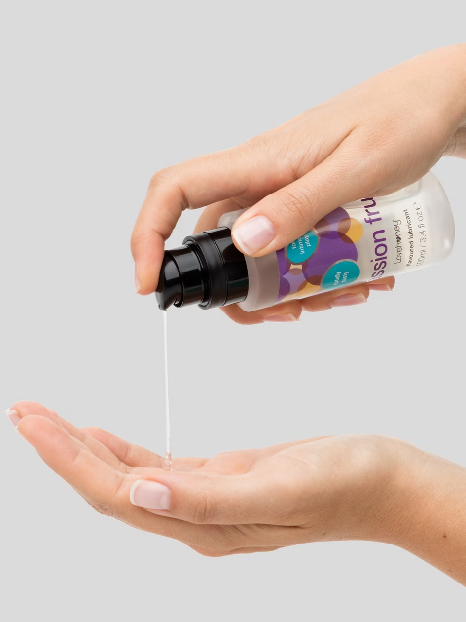 Hand holding a bottle of Fusion Fruit spray over another hand on a gray background
