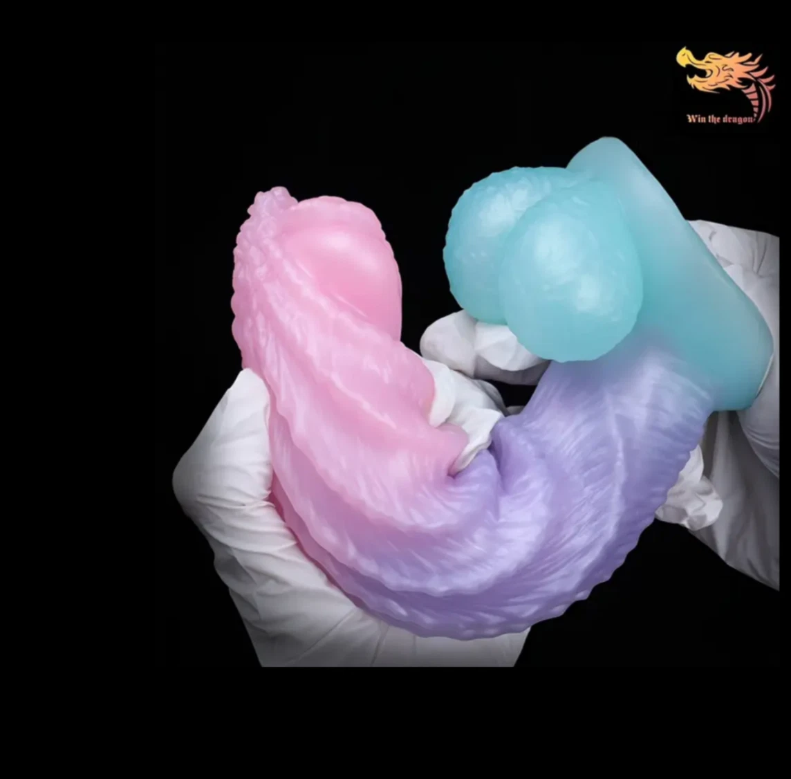 Pink and blue silicone mold held by a gloved hand on a black background