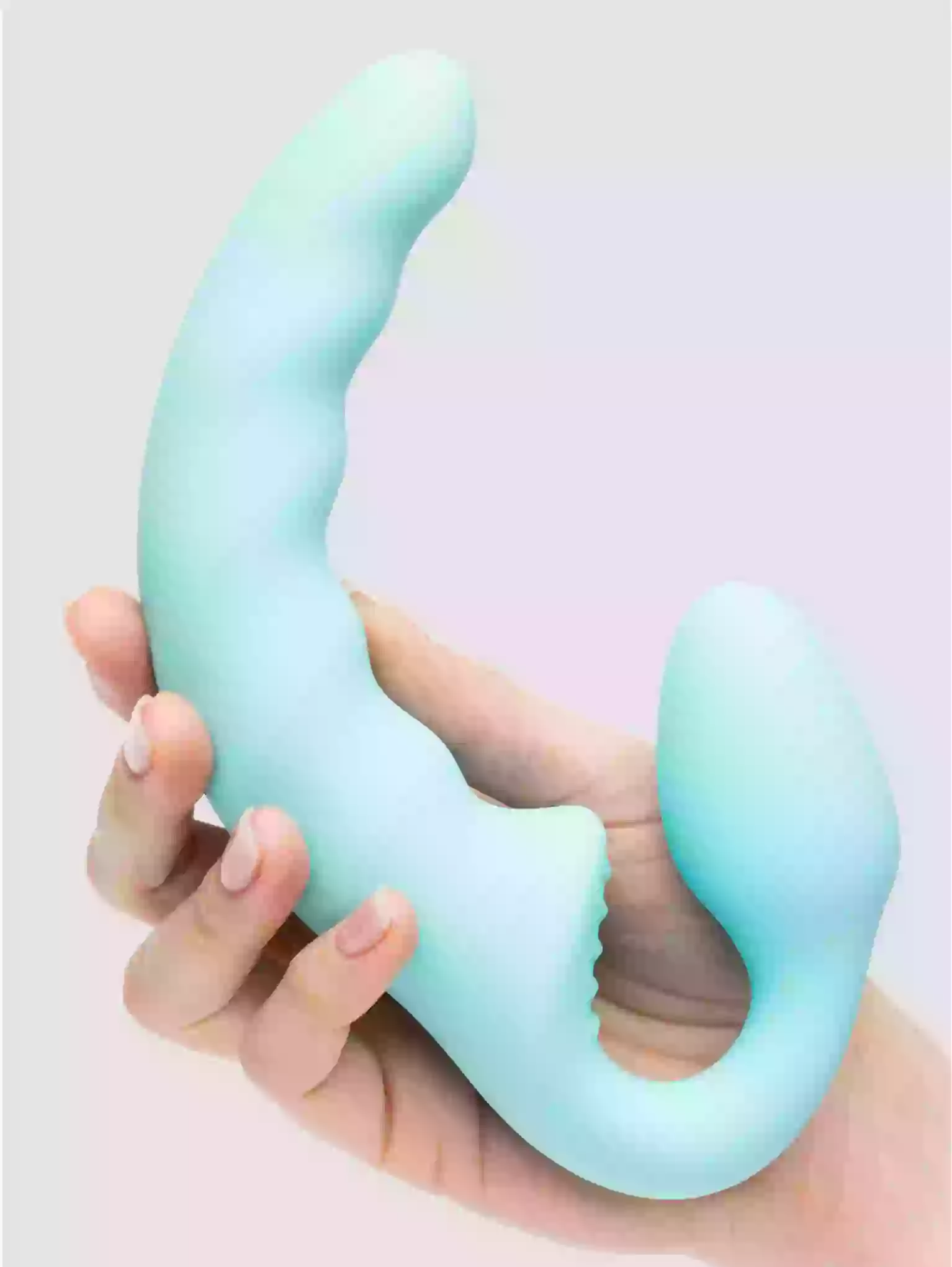Hand holding a pastel green silicone product against a light background