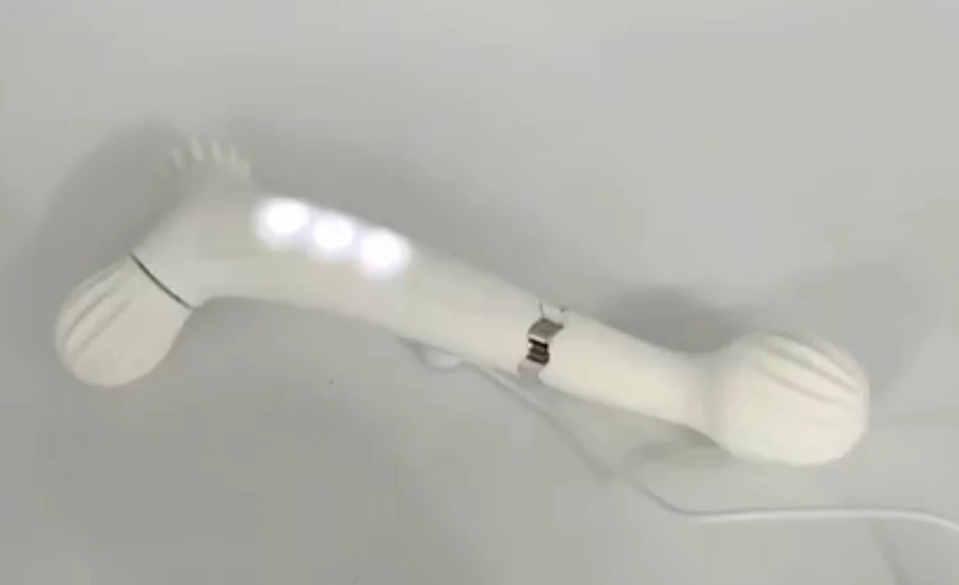 White plastic object with a handle on a light gray background