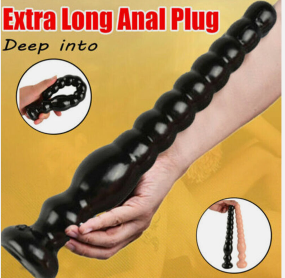 Extra long black anal plug held by a hand on a yellow background with text.