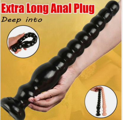 Extra long black anal plug held by a hand on a yellow background with text.