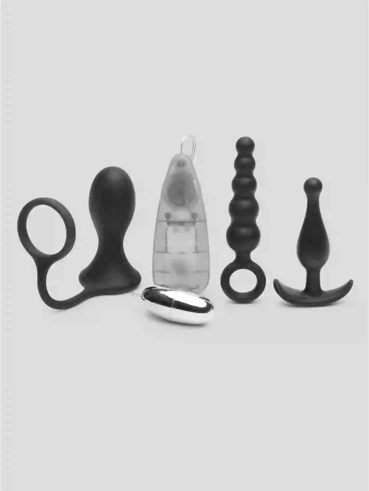 Set of black and silver butt plugs on a light gray background