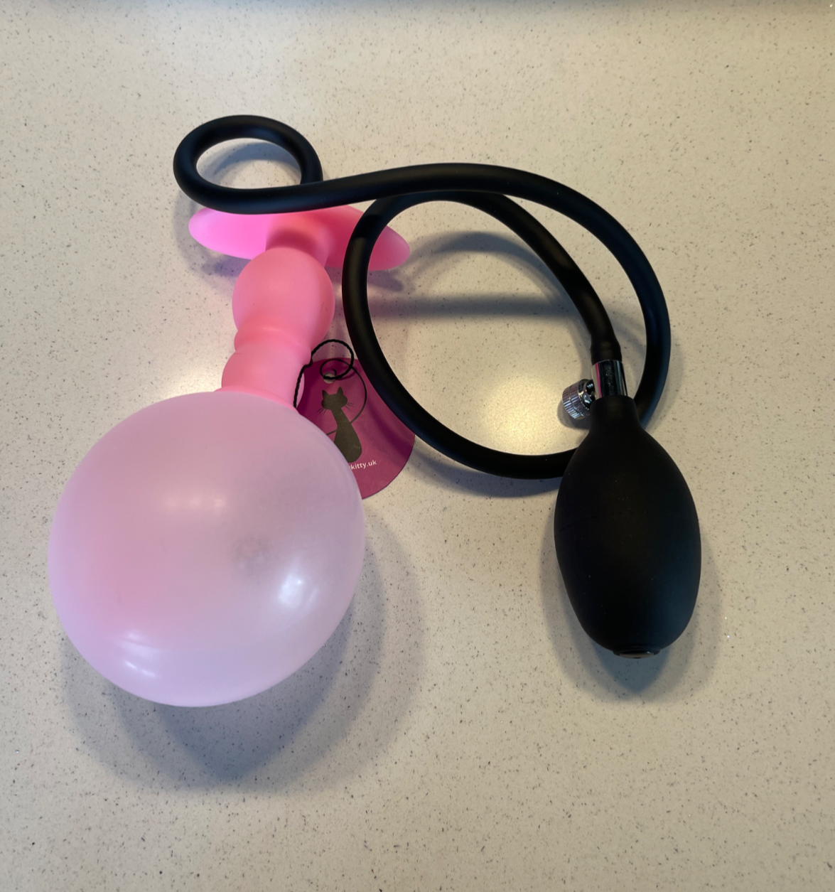 Pink and black balloon pump on a light surface
