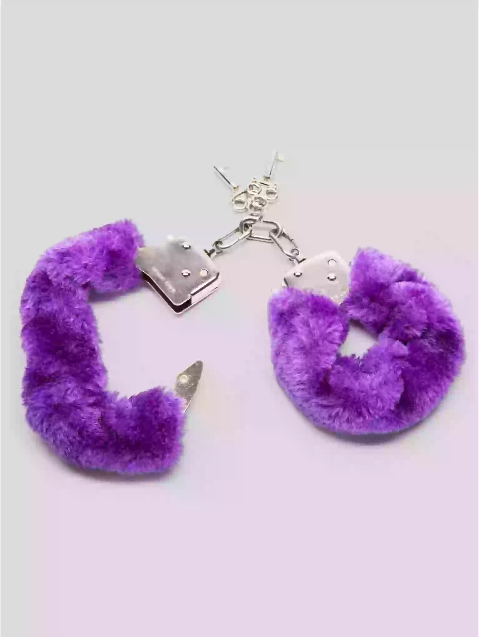Purple fuzzy handcuffs keychain on a light gray background