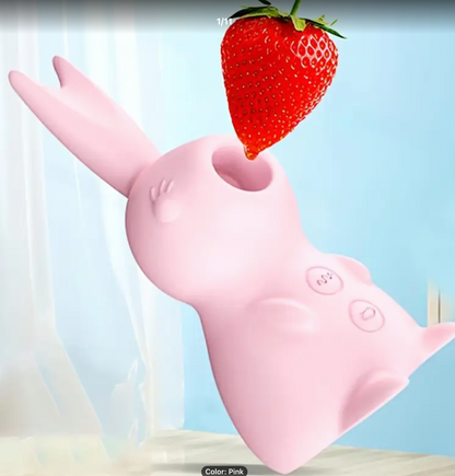 Pink rubber glove holding a strawberry against a light blue background