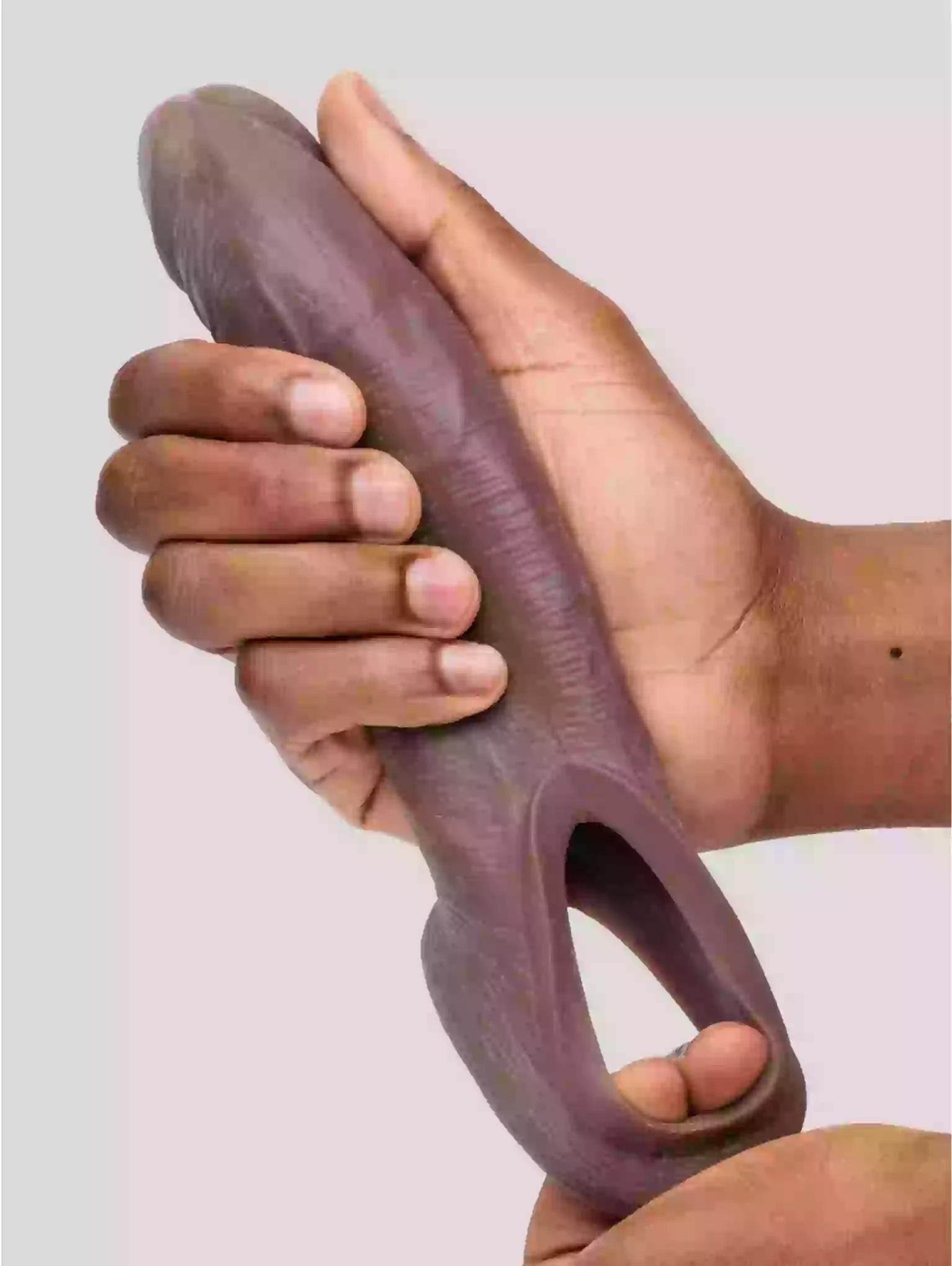 Hand holding a purple silicone tool against a plain background