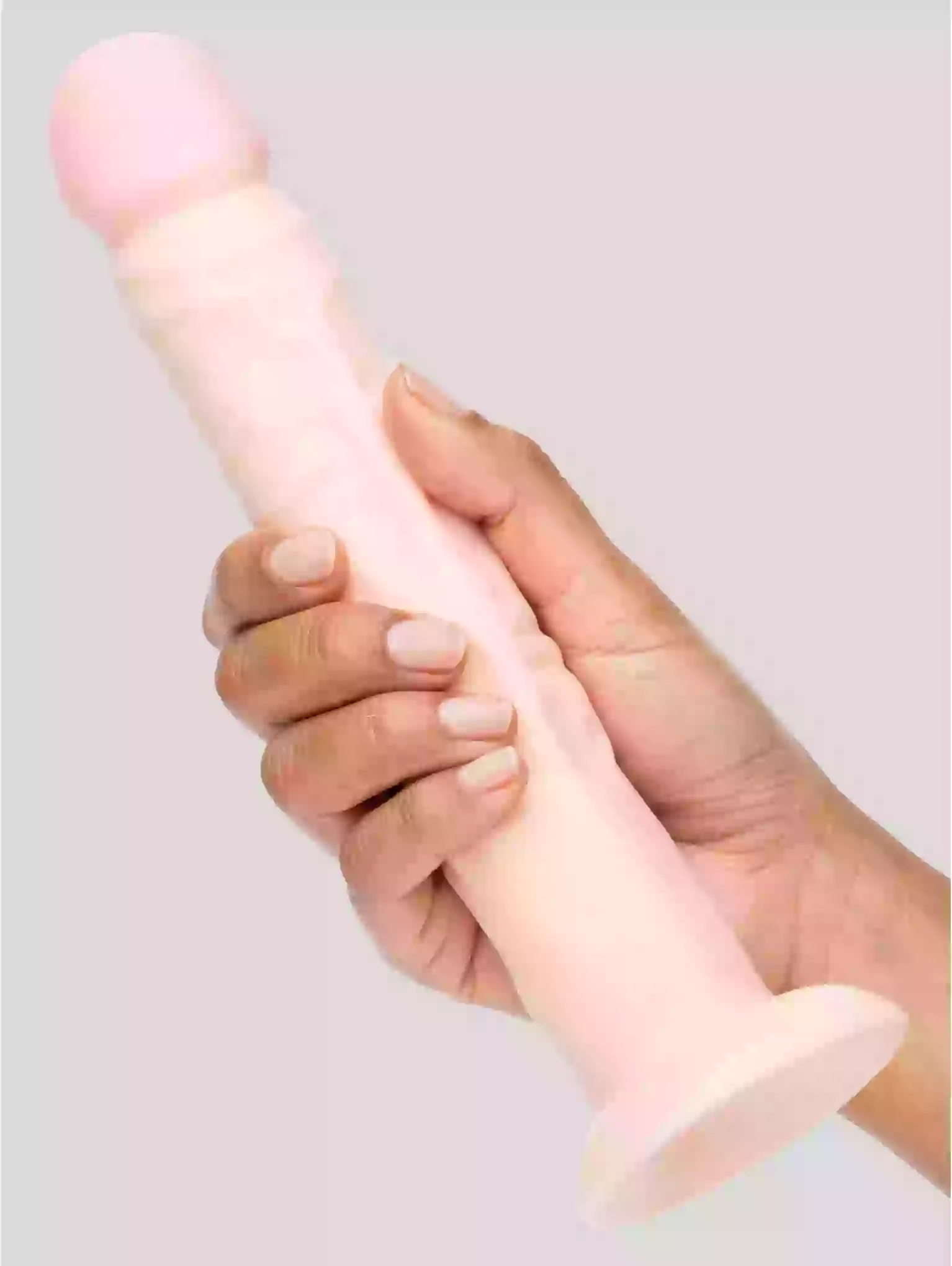 Hand holding a pink and white cylindrical object against a light gray background