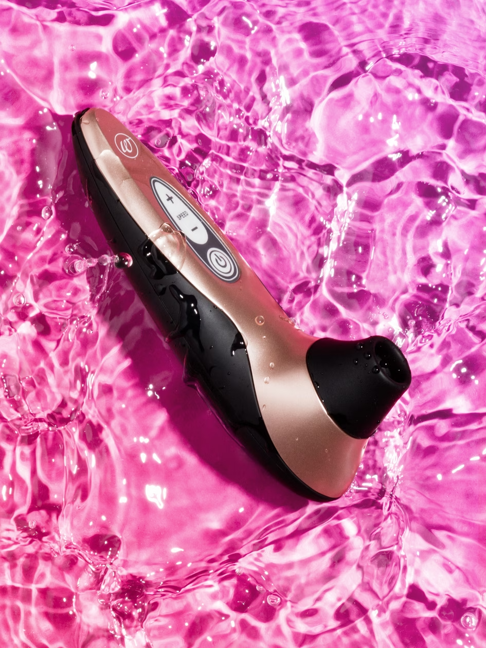 Black and gold electronic device on pink water surface