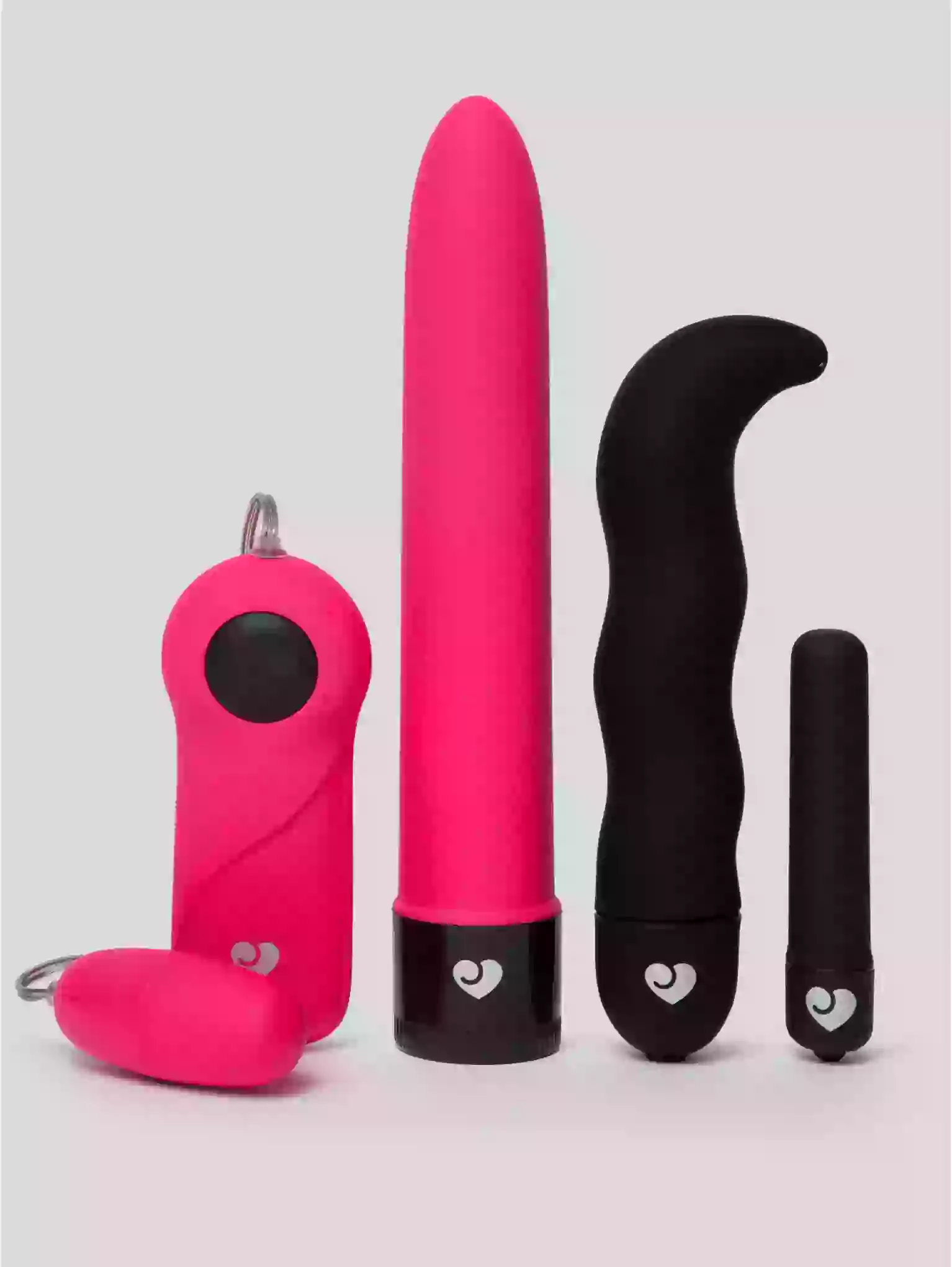 Set of pink and black sex toys on a light gray background