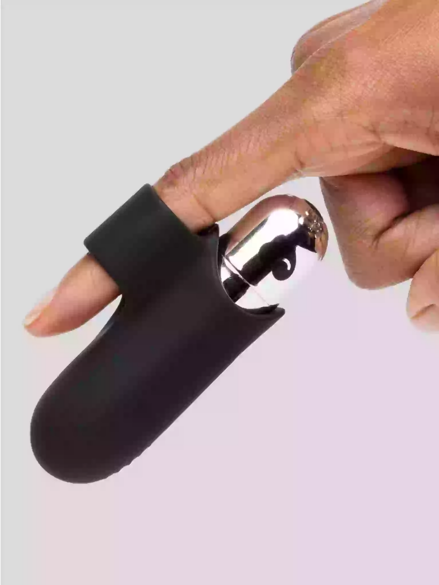 Black and silver device held by a hand on a light gray background
