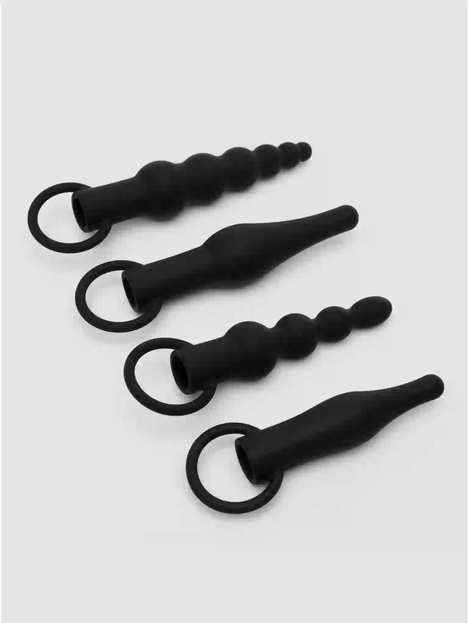 Four black silicone butt plugs of varying sizes on a white background
