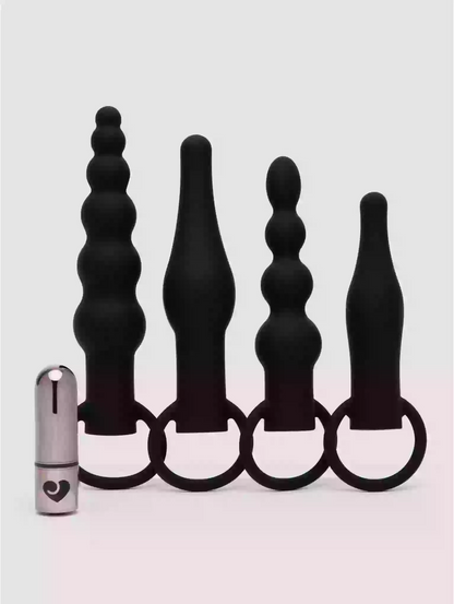 Set of black silicone butt plugs with a metal ring on a white background